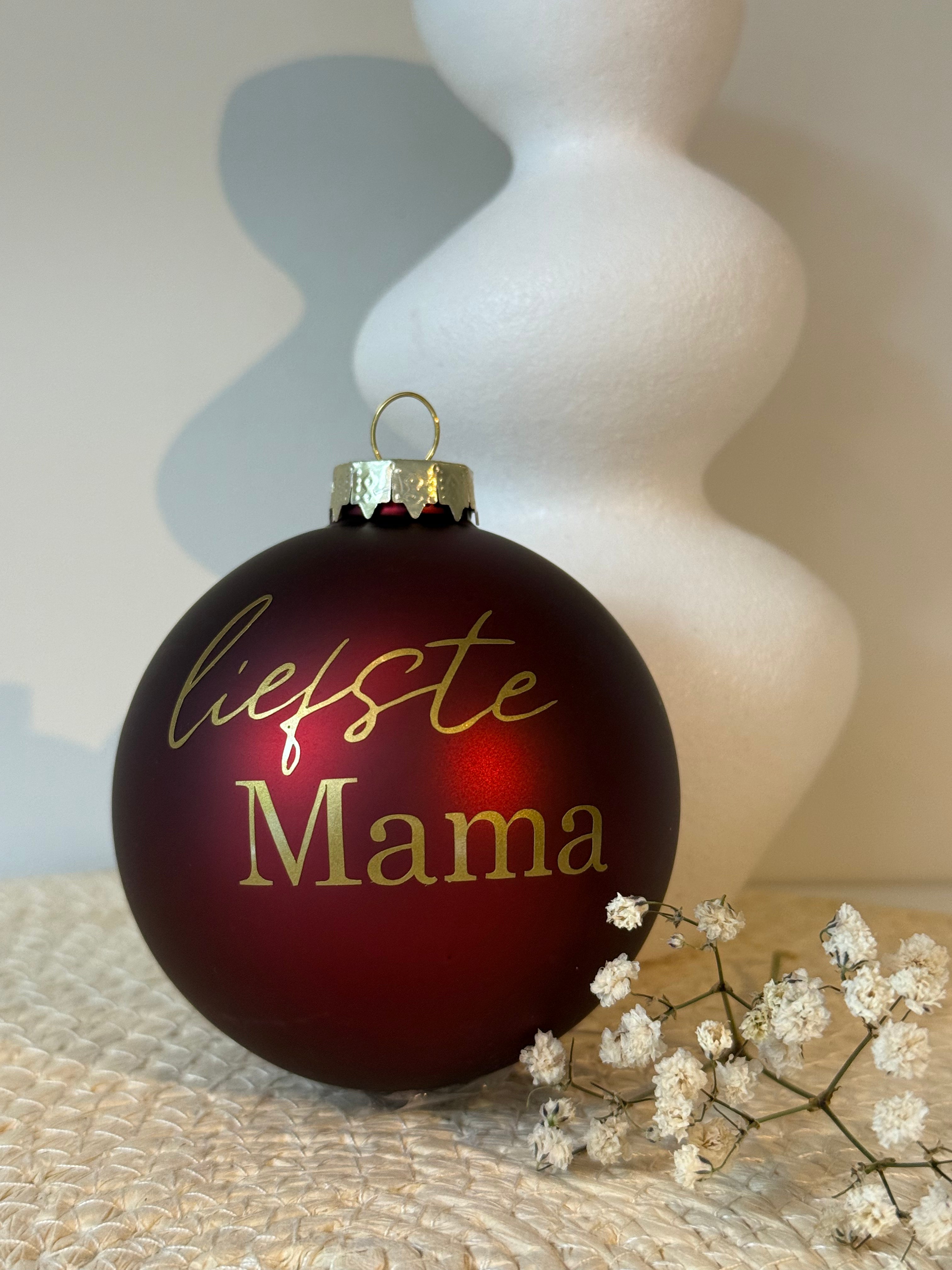Bordeauxrode glazen kerstbal met de goudkleurige tekst Liefste mama en een matte afwerking.