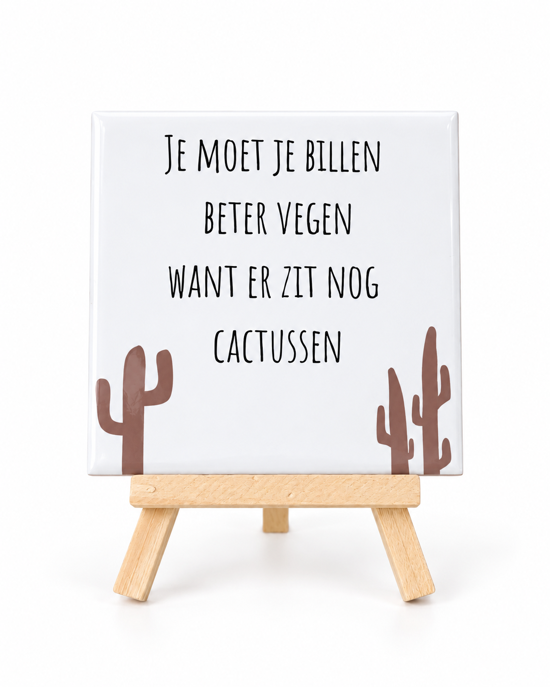 Wit keramieken tegeltje met grappige toilettekst en bruine cactusillustraties, op een houten houdertje tegen een witte achtergrond.