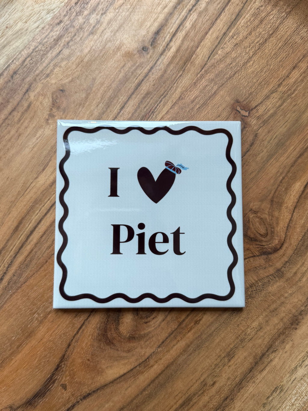 Sinterklaas tegeltje met de tekst I Love Piet op houten ondergrond
